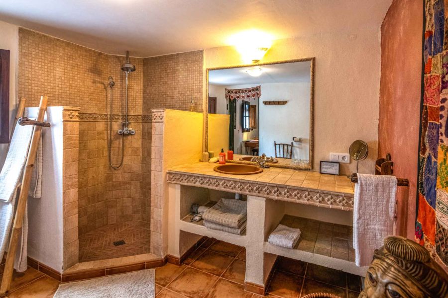 Cuarto de baño espacioso con ducha a ras de suelo, jabones ecológicos y amplia selección de toallas