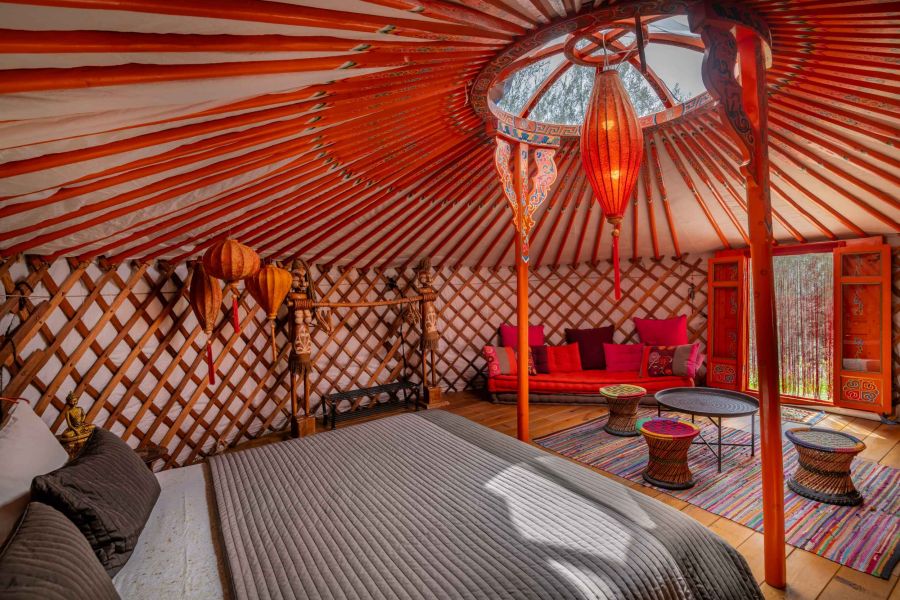 sleeping in a yurt with comfortable double bed and view of olive grove