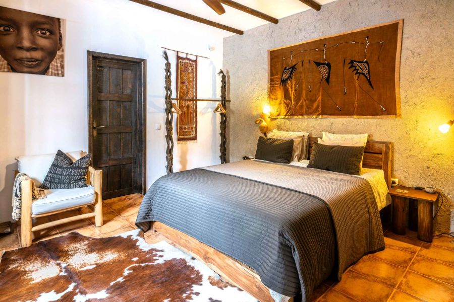 Geräumiges, ethnisch eingerichtetes Zimmer mit bequemem Doppelbett und Lehmwänden